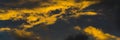 Stunning fluffy thunderstorm clouds illuminated by disappearing rays at sunset and dark thunderclouds floating across