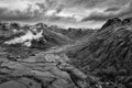 Stunning flying drone  black and white landscape image of Langdale pikes and valley in Winter with dramatic low level clouds and Royalty Free Stock Photo