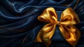 Elegant golden bow on luxurious navy blue satin fabric. perfect for gifting themes and backgrounds. high-quality Royalty Free Stock Photo