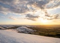 Stunning golden sunrise over snow covered hill Mam Tor mountain in Derbyshire Peak District countryside amazing sky cloudscape. Wi Royalty Free Stock Photo