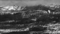 Stunning grayscale shot of an impressive mountain range enveloped in billowing clouds