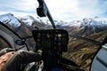 Stunning helicopter cockpit image with snowy Mount Aspiring in the background on a sunny winter day, New Zealand