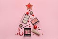 Beautiful Christmas tree made of makeup cosmetics and decor on pink background