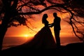 A stunning image of a bride and groom standing in silhouette against a magnificent sunset, creating a romantic and magical Royalty Free Stock Photo