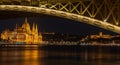 a large bridge over the water and buildings are lit up in yellow lights Royalty Free Stock Photo
