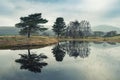 Stunning landscape image of dramatic storm clouds over Kelly Hall Tarn in Lake District during late Autumn Fall afternoon Royalty Free Stock Photo