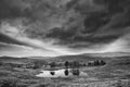 Stunning landscape image of dramatic storm clouds over Kelly Hall Tarn in Lake District during late Autumn Fall afternoon Royalty Free Stock Photo