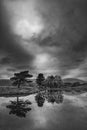 Stunning landscape image of dramatic storm clouds over Kelly Hall Tarn in Lake District during late Autumn Fall afternoon Royalty Free Stock Photo