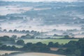 Glorious landscape image of layers of mist rolling over South Downs National Park English countryside during misty Summer sunrise Royalty Free Stock Photo