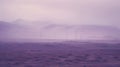 Purple Sky Over Windmills: A Hazy Landscape Of Desert Mist And Renewable Energy