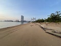 Stunning landscape of a tranquil beach with buildings in the distance in Seberang Takir, Malaysia