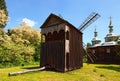 Stunning landscape view of wooden ancient windmill and typical wooden church. Pereyaslav-Khmelnitsky Museum of Folk Architecture