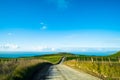 The stunning landscape of the way in a rural area in New Zealand. Gravel road among green grassland with blue sky. I Royalty Free Stock Photo