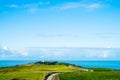 The stunning landscape of the way in a rural area in New Zealand. Gravel road among green grassland with blue sky. I Royalty Free Stock Photo