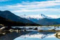Stunning landscpae of the reflection of the snow mountain on the river. Blue sky and some cloudy. I