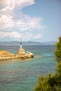 Stunning lighthouse situated atop a rocky outcrop jutting out into the sparkling blue waters