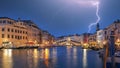 Stunning lightning at night sky over city of f Venice with famous Canal Grande and Rialto Bridge
