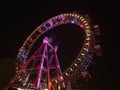 Stunning low angle view of popular Ferris wheel with colorful rim at night in amusement park Prater in Vienna, Austria. Royalty Free Stock Photo