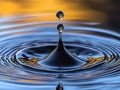 Stunning macro photograph of a water droplet impacting a surface, creating mesmerizing concentric ripples. The goldenhued