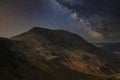 Stunning majestic digital composite landscape of Milky Way over Haystacks and High Stile in Lake District