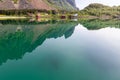 A stunning mirror reflection in the calm waters of a Lofoten fjord captures the summer greenery and iconic Rorbu cabins Royalty Free Stock Photo