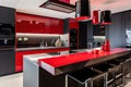 a stunning modern kitchen, with bold red and black elements, including a custom-made countertop and sleek black fixtures