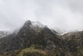 Stunning moody dramatic Winter landscape image of snowcapped Y Garn mountain in Snowdonia