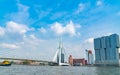 Stunning mordern Erasmus cable stay bridge with port tug boat passing under and modern De Rotterdam building on waterfront on Royalty Free Stock Photo