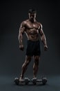 Stunning muscular bodybuilder posing over black background