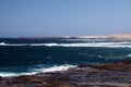 Stunning natural viewpoint with bare dry hills, turquoise lagoon and furious wild sea at north-west coast of Fuerteventura, Canary