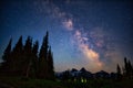 Stunning nighttime landscape featureing a brilliant Milky Way illuminating mount Rainier and trees
