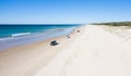 Holiday makers enjoying the beach. Tourists enjoy driving and stopping with their car, 4wd driving on infinite beach. Royalty Free Stock Photo