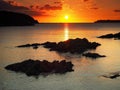 Stunning orange sunset over West Angle Bay and fishing boat Pembrokeshire, Wales