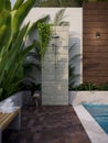 Stunning outdoor shower in the tropical green garden by the pool in luxury pool villa