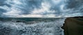 Stunning panoramic 180 degrees of rough sea at sunset on blue hour at beach, a dramatic sky with amazing light and cloudscape and Royalty Free Stock Photo