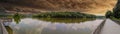 A stunning panoramic shot of the silky brown water of the Chattahoochee river surrounded by lush green trees Royalty Free Stock Photo