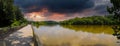 A stunning panoramic shot of the silky brown water of the Chattahoochee river surrounded by lush green trees