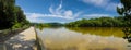 A stunning panoramic shot of the vast still silky brown water of the Chattahoochee river with a long wooden boardwalk