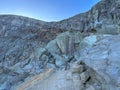 Stunning panoramic views of the Ijen Crater with large rocks and a bright blue sky in the background