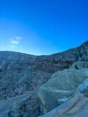 Stunning panoramic views of the Ijen Crater with large rocks and a bright blue sky in the background