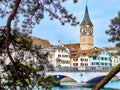 The Peterskirche church framed by the pine tree branches offers a captivating view in Zurich, Switzerland