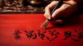 Elegant Brush Creating Chinese Calligraphy on Red Paper Royalty Free Stock Photo