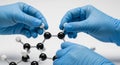 Precision Assembly of Organic Chemistry Model with Nitrile Gloved Hands Royalty Free Stock Photo