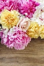 Stunning pink peonies, yellow carnations and roses on rustic woo Royalty Free Stock Photo