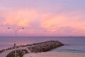 Pastel pink sunset over ocean rock wall groyne at Cottesloe Beach Royalty Free Stock Photo