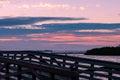 Stunning pinky morning dawn cloudscape over a wooden pier by a seaside Royalty Free Stock Photo