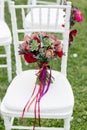 Stunning red bridal bouquet on white chair. Wedding ceremony. Mix of succulents, orchids and roses Royalty Free Stock Photo