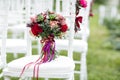 Stunning red bridal bouquet on white chair. Wedding ceremony. Mix of succulents, orchids and roses Royalty Free Stock Photo