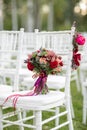 Stunning red bridal bouquet on white chair. Wedding ceremony. Mix of succulents, orchids and roses Royalty Free Stock Photo