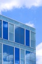 Stunning reflection on surface of modern glass office building against white cloud on blue sky background Royalty Free Stock Photo